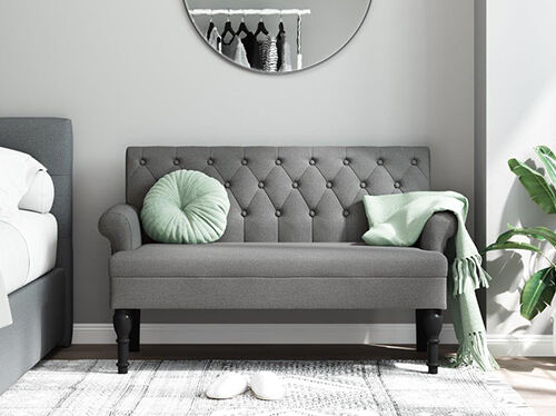 Szara tapicerowana sofa dwuosobowa w stylowo urządzonej sypialni. Kliknij, aby zobaczyć produkty.