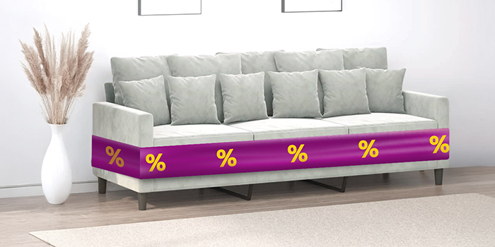 Szara sofa trzyosobowa z poduszkami i fioletową wstążką z ikonami rabatów w stylowo zaprojektowanym salonie. Kliknij, aby kupić produkty z oferty.